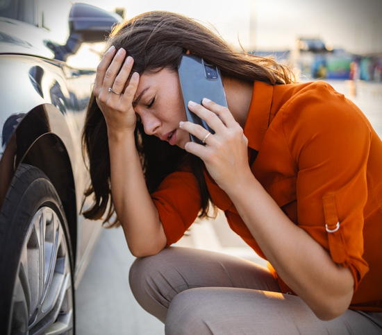 woman in distress with broken down car