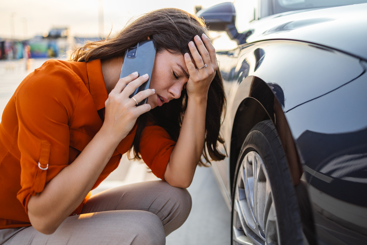 woman in distress with broken down car