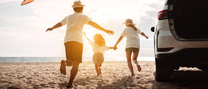 happy family at the beach by car with extended warranty