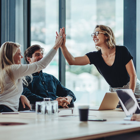 high five at a business board meeting